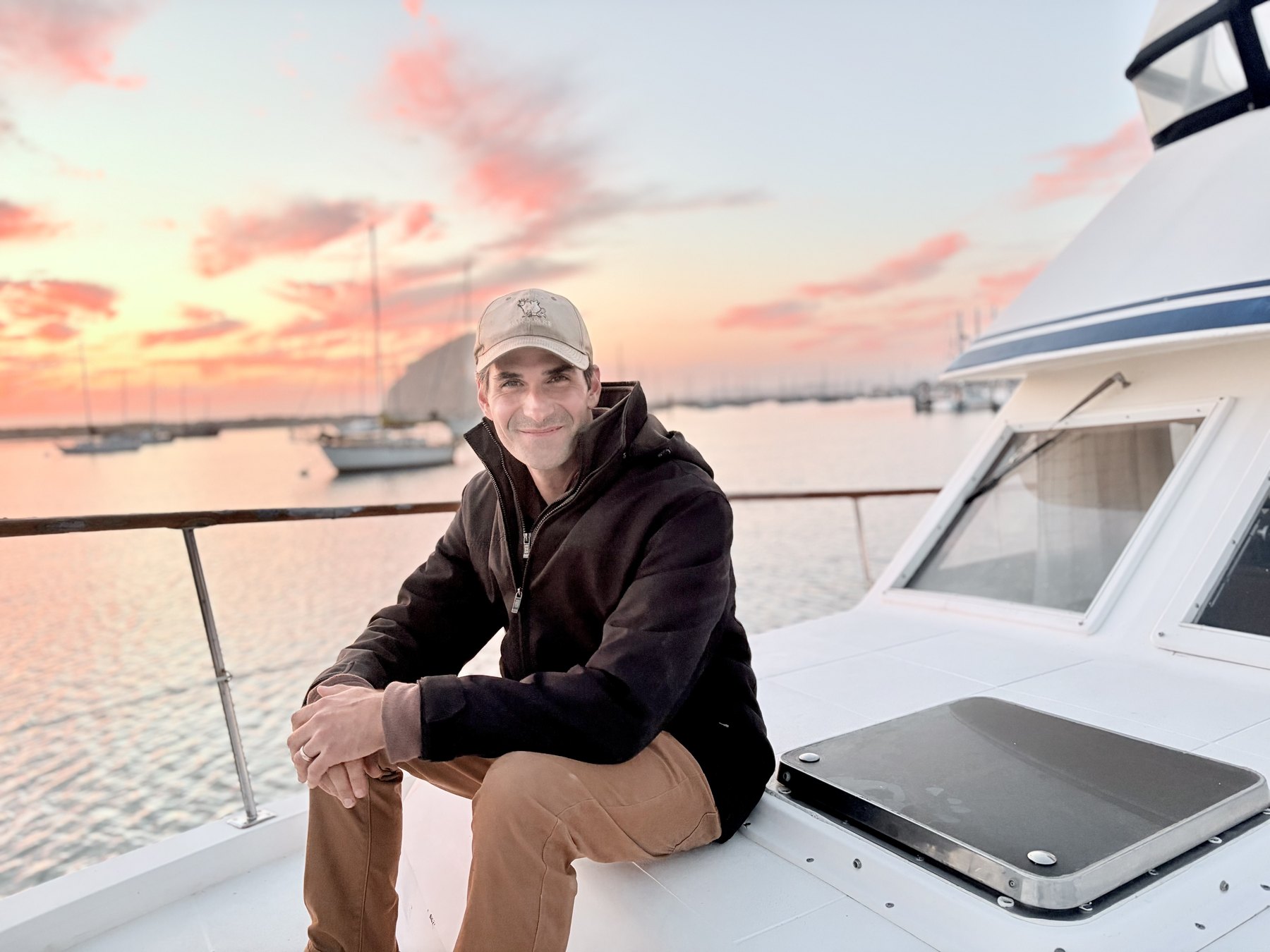 David sitting aboard a boat in Morro Bay at sunset